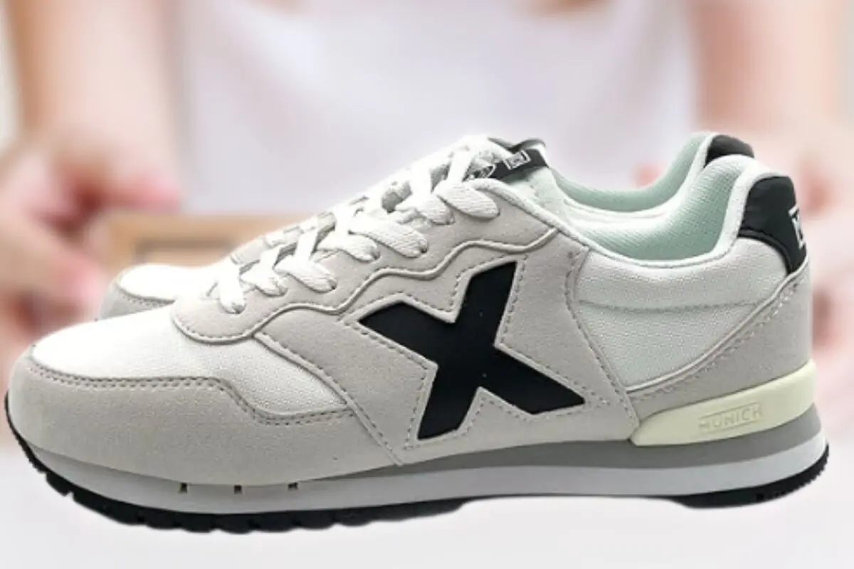 Zapatillas deportivas blancas con suela gruesa y gran X negra en el lateral