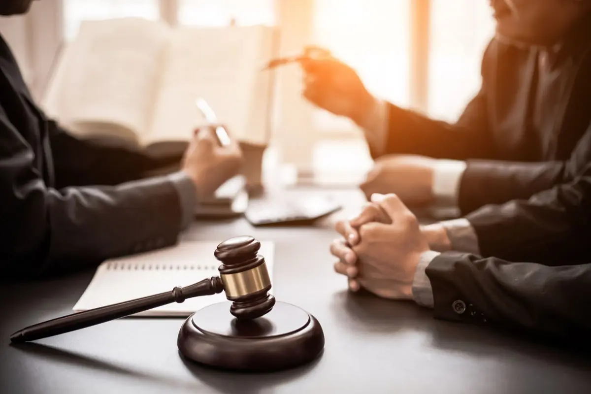 Reunió d’advocats en una taula amb un mall de jutge en primer pla