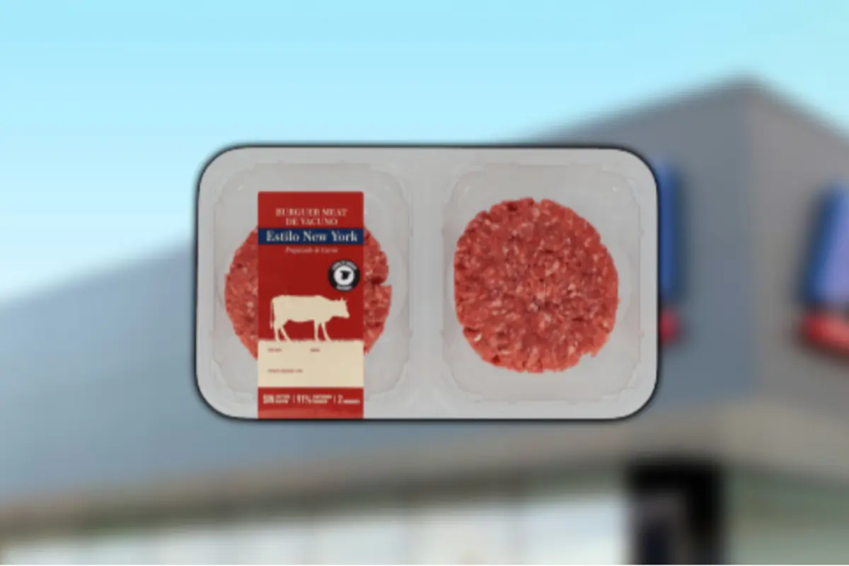 Bandeja de dos hamburguesas de carne molida estilo New York en empaque transparente sobre fondo desenfocado Bandeja de dos hamburguesas de carne molida estilo New York en empaque transparente sobre fondo desenfocado