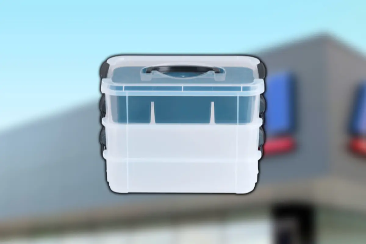 Caixa organitzadora de plàstic transparent amb tapa i nansa negra sobre fons desenfocat