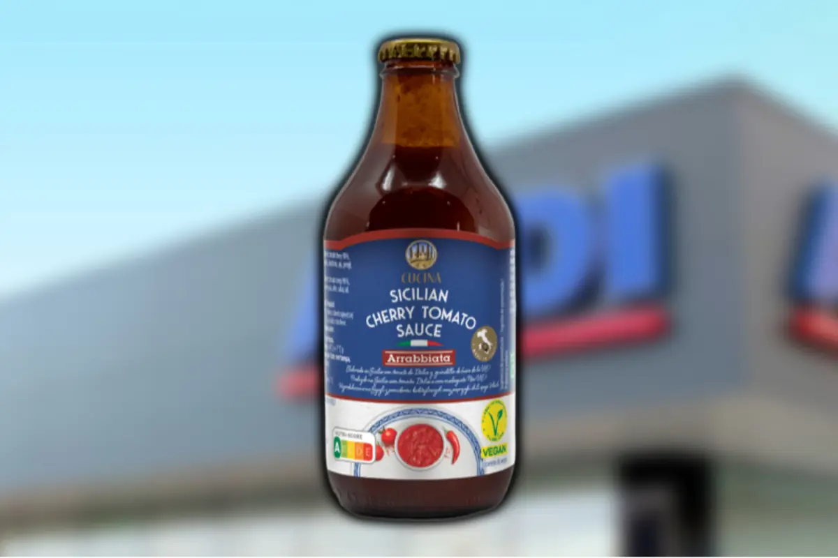 Botella de salsa siciliana de tomate cherry arrabbiata marca Cucina sobre fondo desenfocado de supermercado