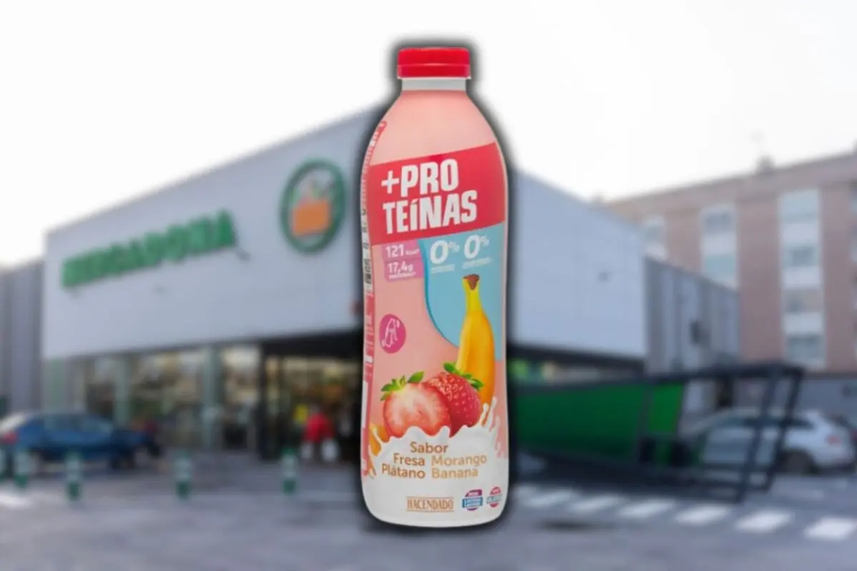 Botella de batido de proteínas sabor fresa y plátano de la marca Hacendado frente a un supermercado Mercadona desenfocado