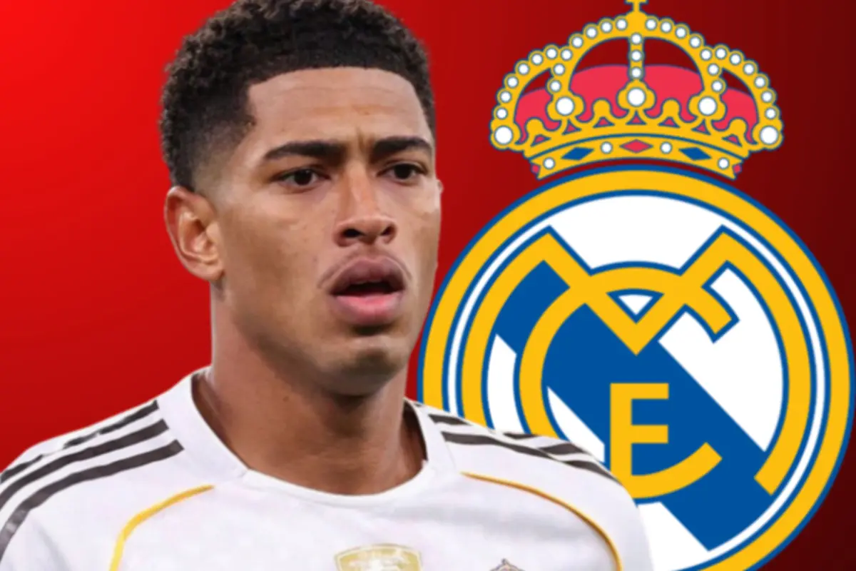 Futbolista amb samarreta blanca del Reial Madrid posant davant de l’escut del club sobre fons vermell