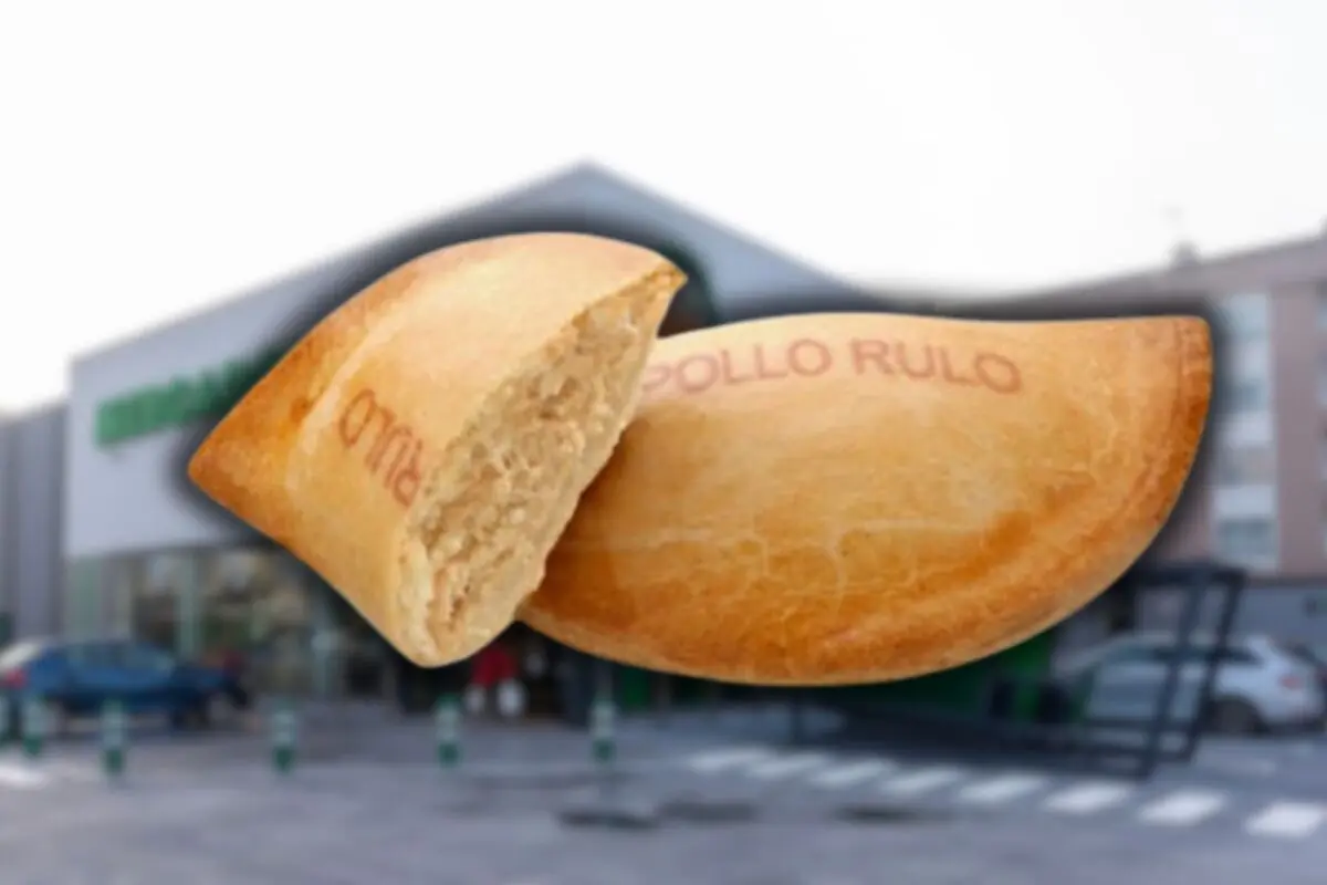 Empanadilla de pollo partida por la mitad sobre un fondo desenfocado de supermercado