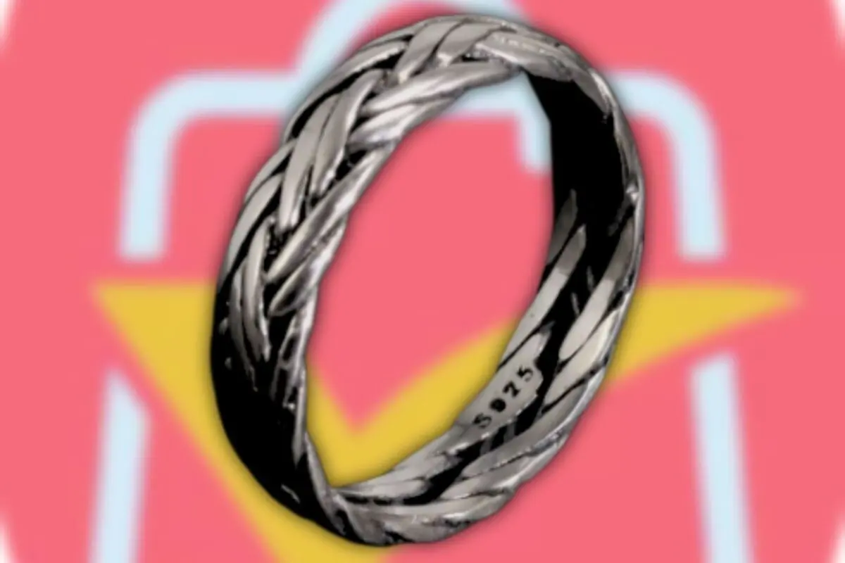 Anillo de plata tejido con diseño trenzado sobre fondo rosa con figura amarilla y contorno blanco