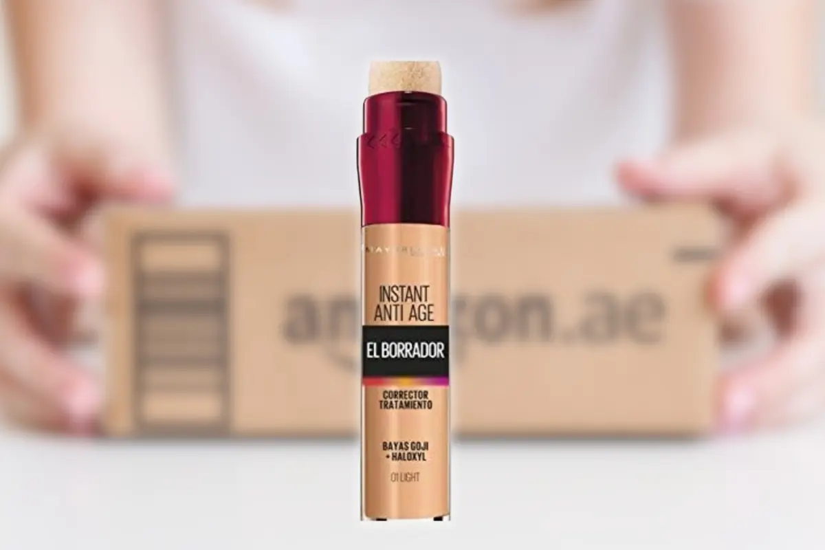 Corrector de ojeras Maybelline Instant Anti Age El Borrador en primer plano con un paquete de Amazon desenfocado de fondo