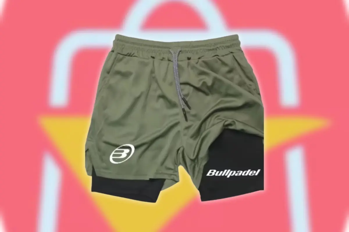 Pantalón corto deportivo verde con malla interior negra y logotipo Bullpadel sobre fondo desenfocado con el logo de AliExpress