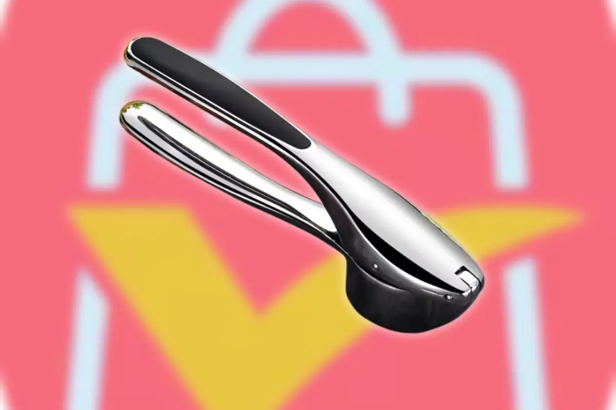 Pelador manual de ajos de acero inoxidable sobre fondo desenfocado con el logo de AliExpress