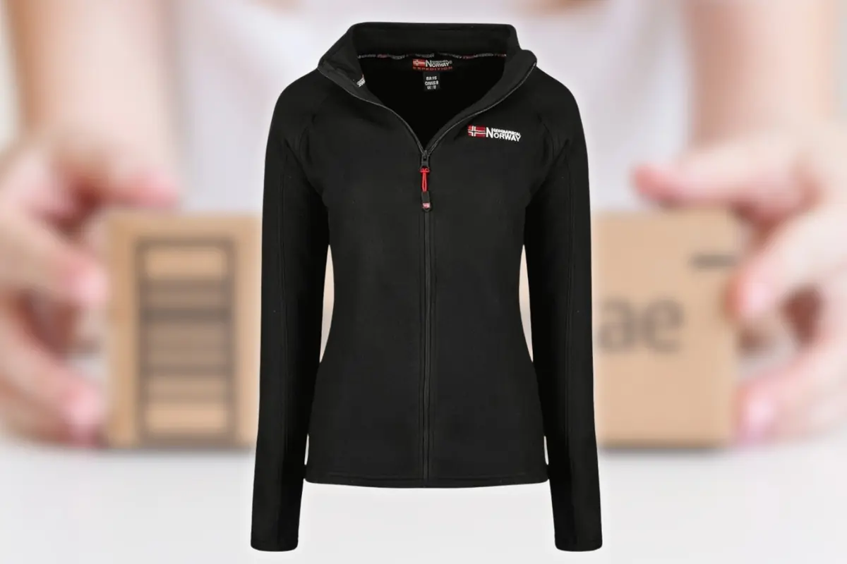 Polar negro con cremallera completa y capucha para mujer sobre fondo desenfocado de manos sosteniendo una caja de cartón