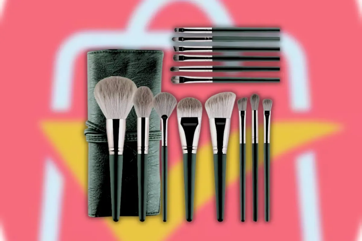 Set de brochas de maquillaje negras con estuche enrollable sobre fondo rosa y amarillo sobre logo desenfocado de AliExpress