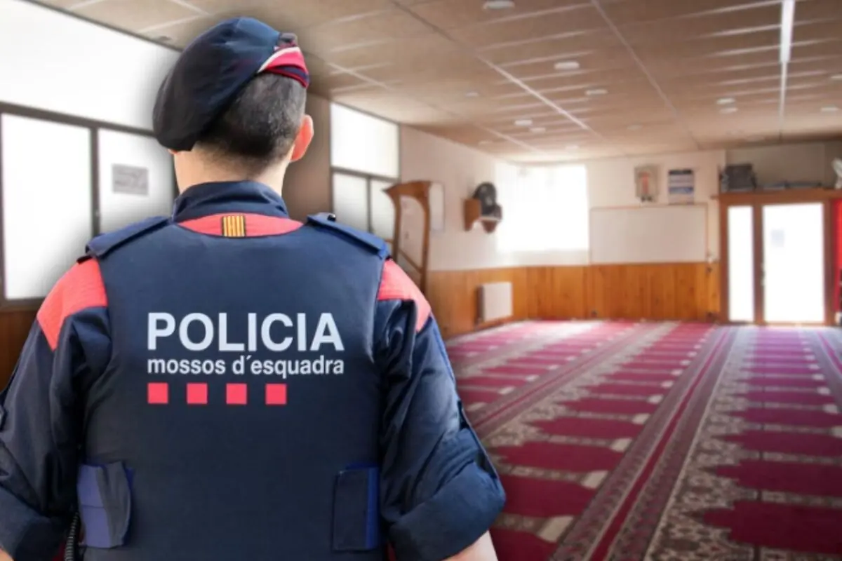 Agent dels Mossos d’Esquadra d’esquena dins d’una sala àmplia enmoquetada amb aspecte de lloc de pregària