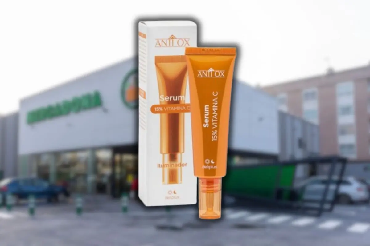 Envase de sérum facial iluminador con vitamina C de la marca Deliplus frente a un supermercado Mercadona desenfocado