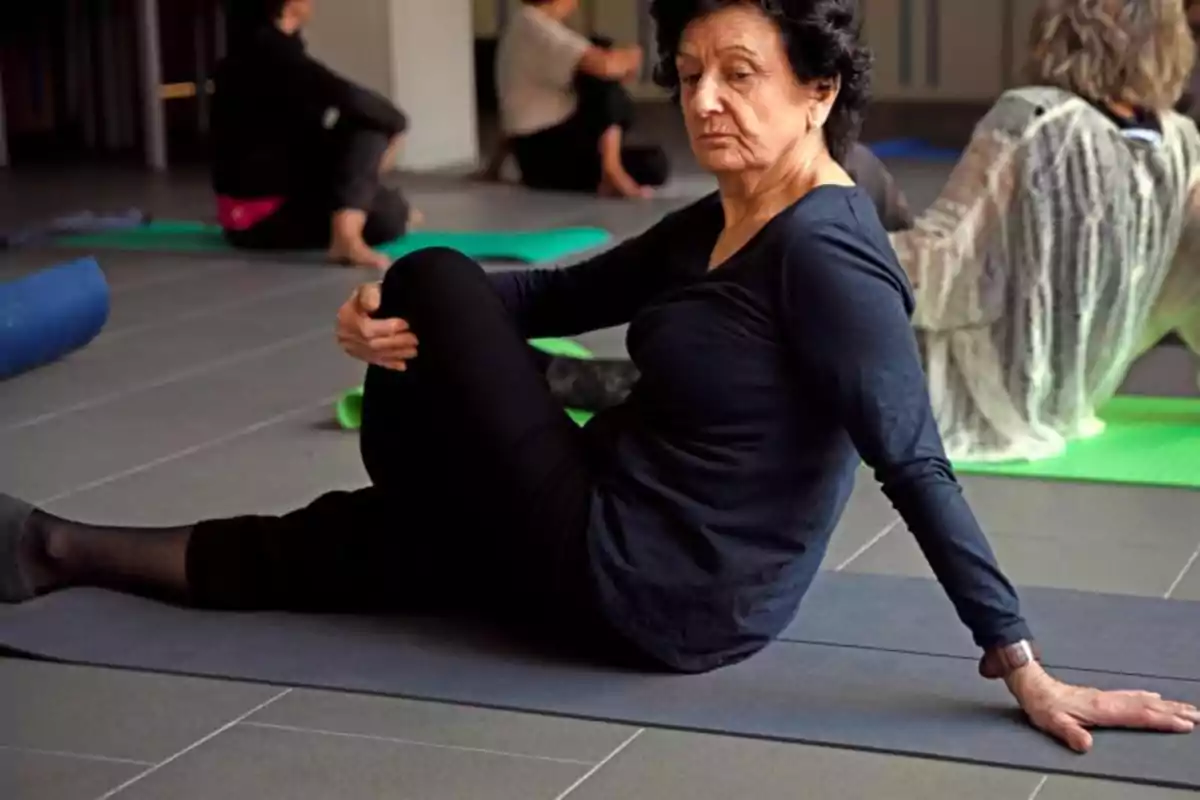 Una dona gran practicant ioga en una classe grupal.