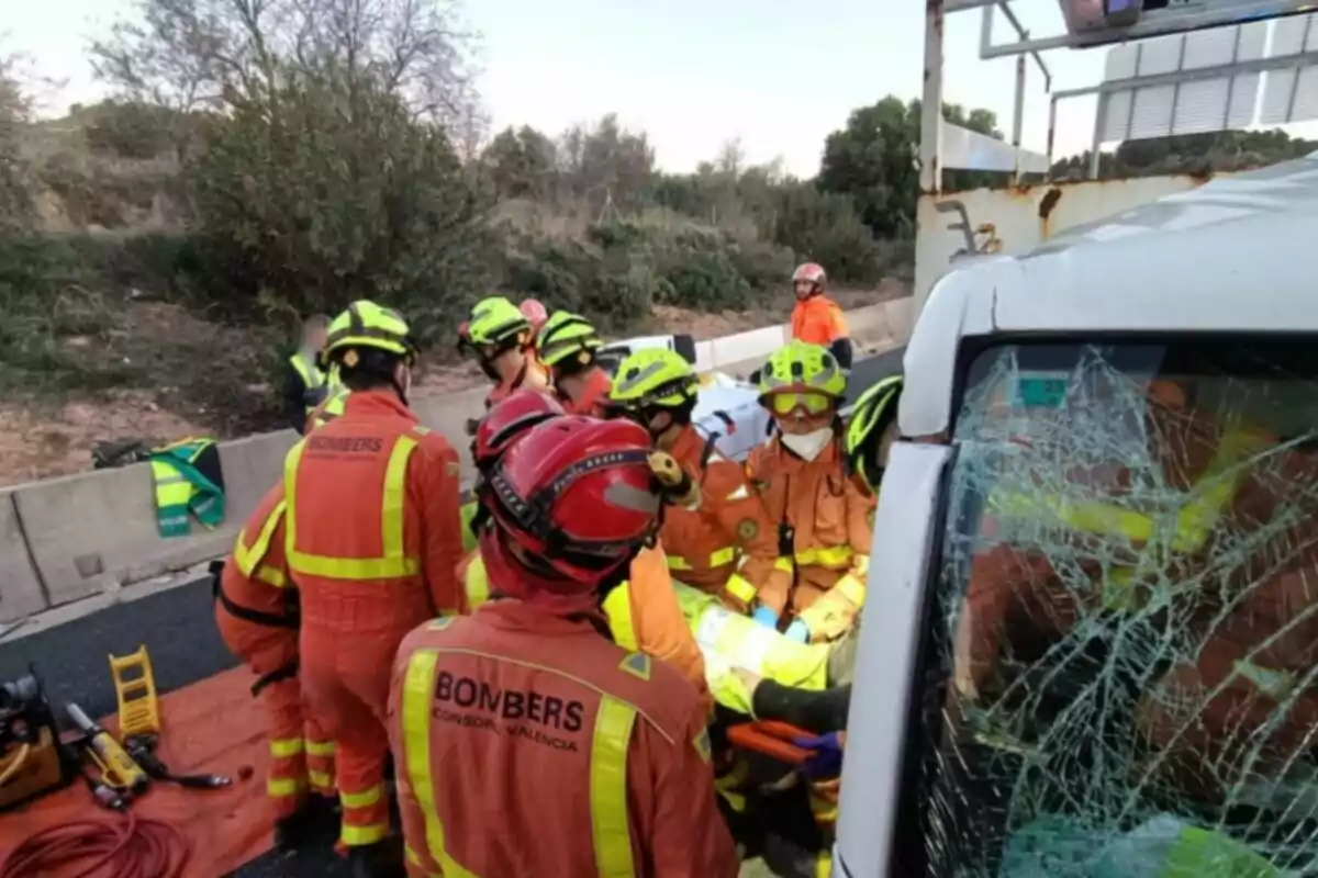 Bombers realitzant un rescat en un accident de trànsit amb un vehicle malmès i un parabrisa trencat.