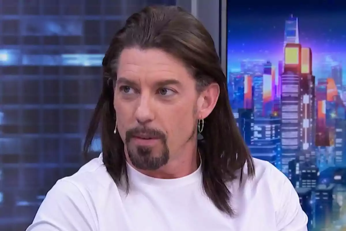 Adrián Lastra amb cabell llarg i barba és a El Hormiguero amb un fons de ciutat il·luminada.