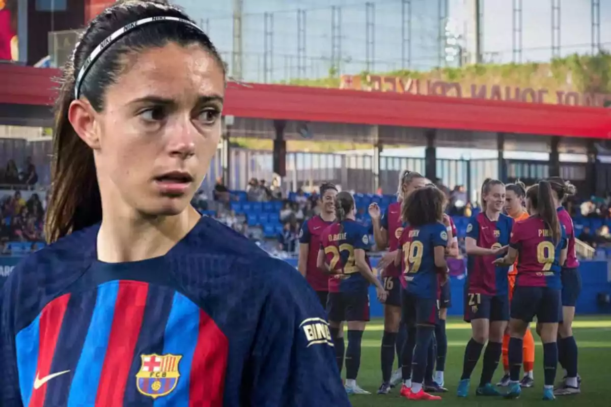 Una jugadora de l?equip de futbol femení del Barcelona apareix en primer pla mentre les seves companyes celebren al camp de joc al fons.