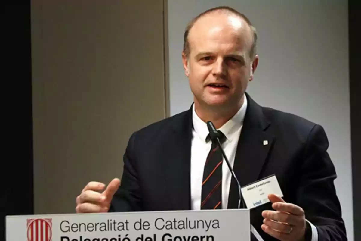 Man in a suit speaking at a podium with a microphone and a Generalitat de Catalunya sign