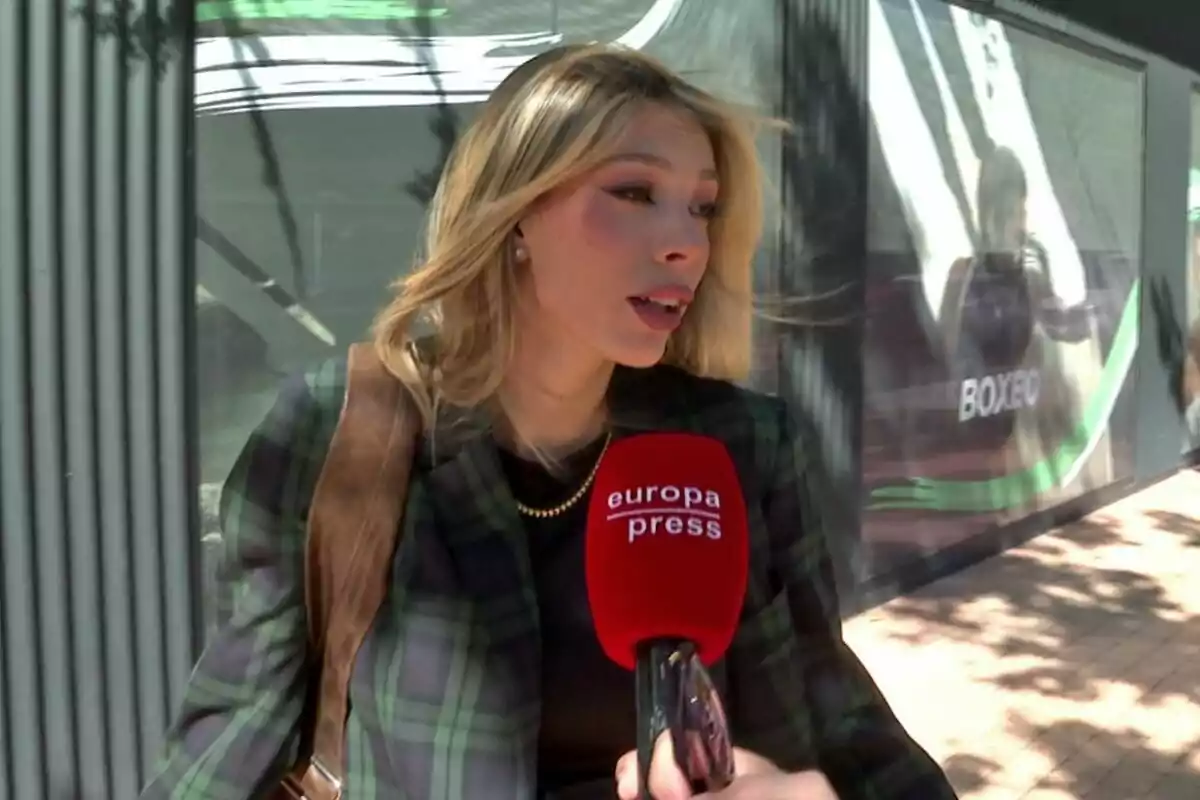 Alejandra Rubio sent entrevistada per un mitjà de comunicació amb un micròfon vermell que diu “europa press”. Alejandra Rubio sent entrevistada per un mitjà de comunicació amb un micròfon vermell que diu “europa press”.
