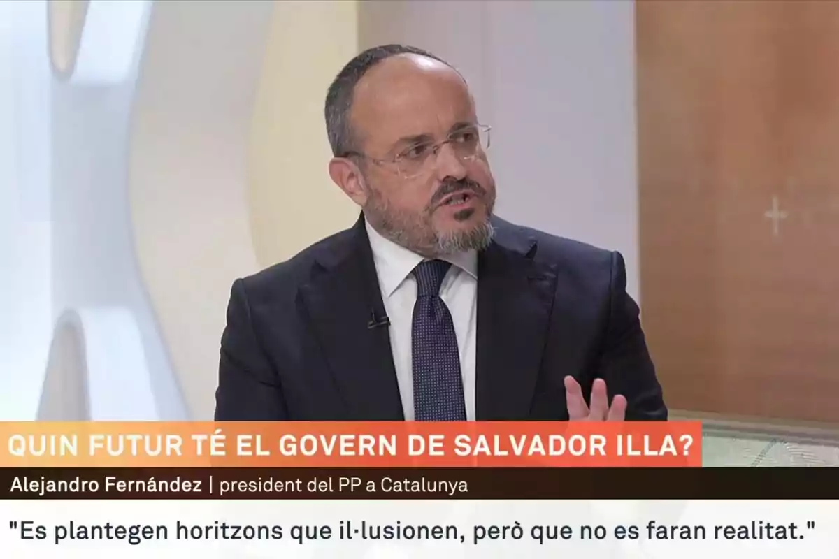 Un home amb barba i ulleres, vestit amb vestit fosc i corbata, parla en un programa de televisió. A la part inferior de la imatge hi ha text en català sobre el futur del govern de Salvador Illa.