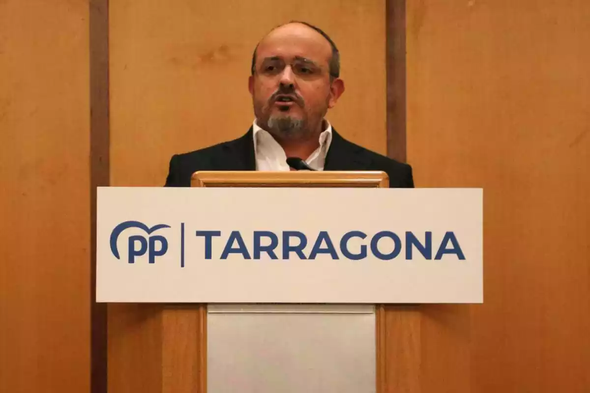 Alejandro Fernández en un faristol amb un cartell del PP Tarragona