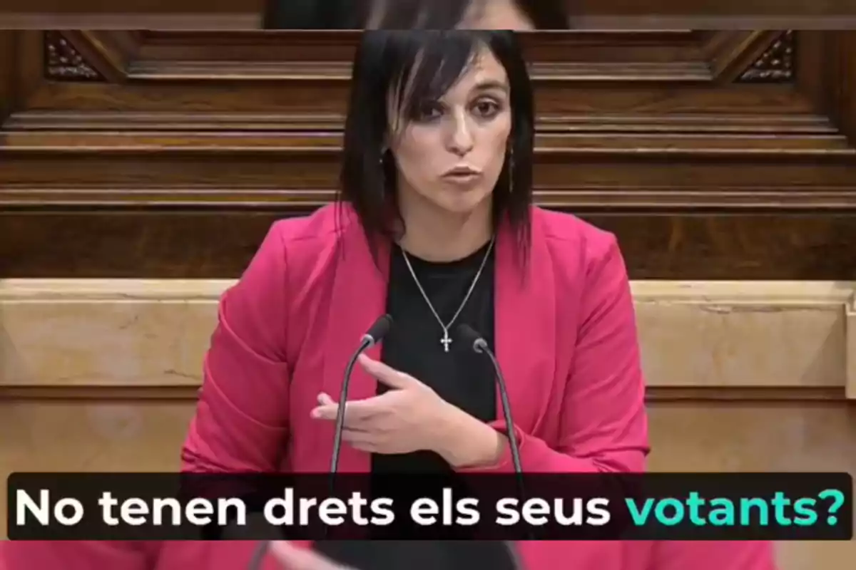 Dona parlant en un podi amb un text en català que diu "No tenen drets els votants?"