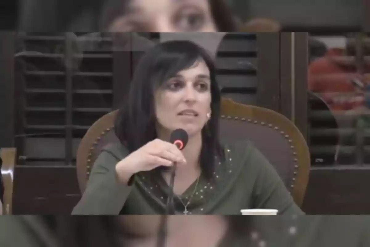 Una persona parlant en un micròfon durant un esdeveniment o conferència.