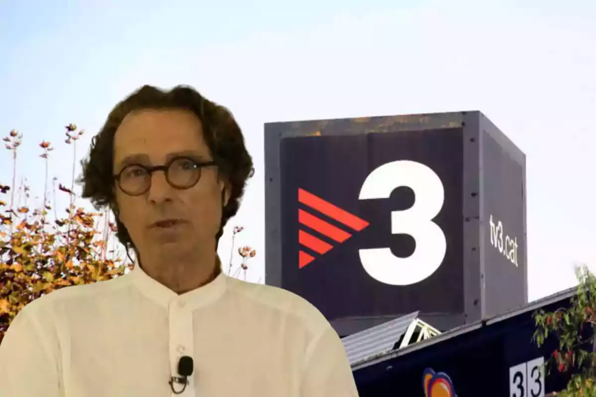 Un home amb ulleres i camisa blanca és davant d’un edifici amb el logotip de TV3 i vegetació al fons.
