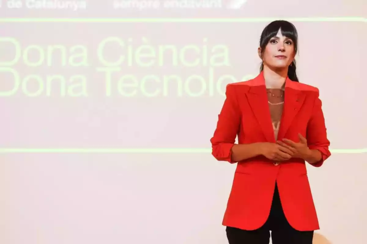 Gina Tost està dreta davant d'una pantalla que diu "Dona Ciència Dona Tecnologia".