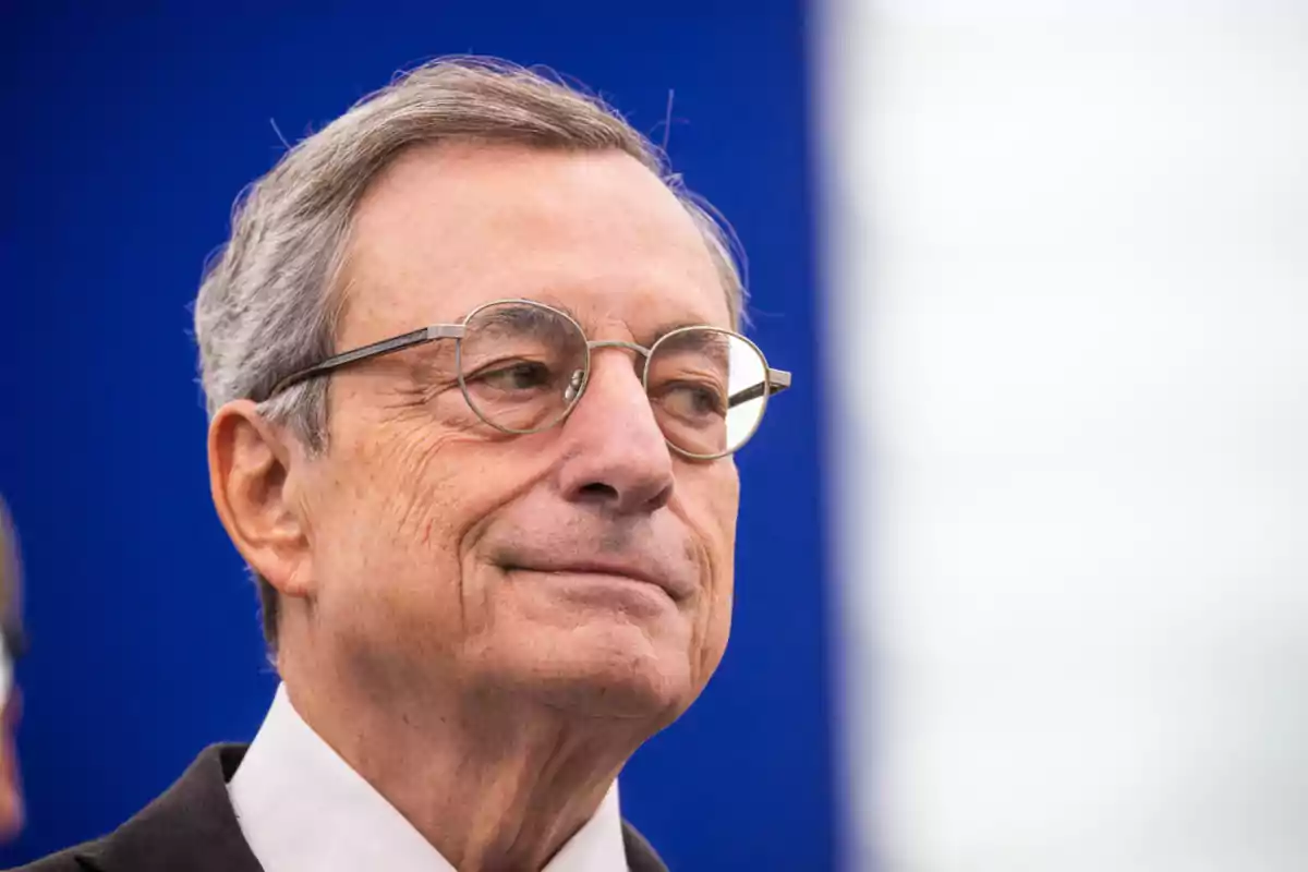 Mario Draghi mira cap a un costat amb una expressió seriosa i un fons blau.