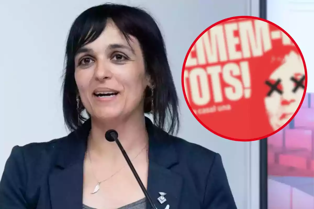 Sílvia Orriols parlant en un micròfon amb un cartell vermell al fons que té una cara amb ulls ratllats.