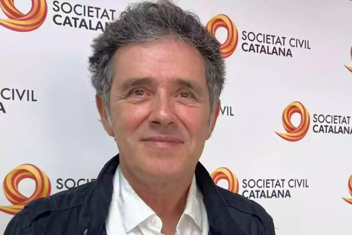 Primer pla d'Àlex Ramos davant un photocall amb diversos logos de Societat Civil Catalana