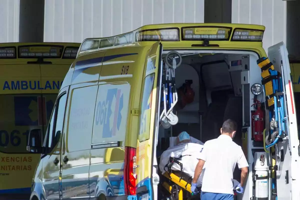 Un professional sanitari baixa d'una ambulància en llitera a un pacient que ha estat traslladat a Galícia (Espanya)