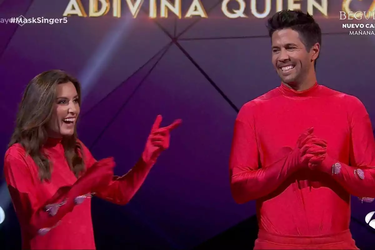 Ana Boyer i Fernando Verdasco vestides amb vestits vermells somriuen en un escenari de Mask Singer amb el text 