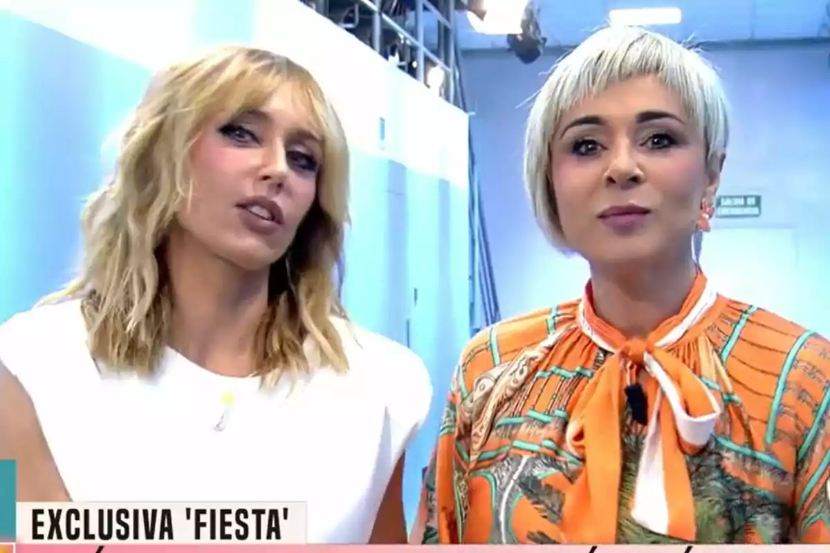 Emma García y Ana María Aldón posan juntas en Fiesta, una lleva una blusa blanca y la otra una blusa naranja con estampado.