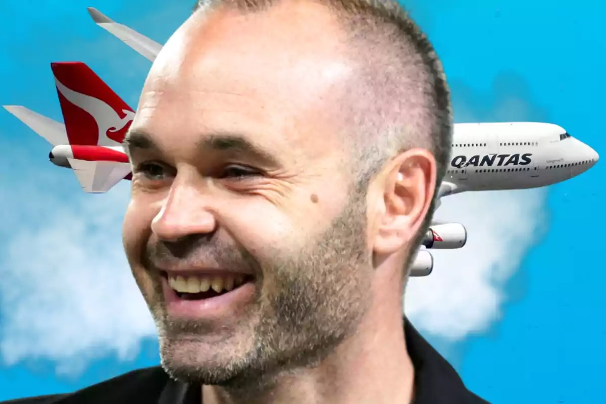 Un hombre sonriente en primer plano con un avión de Qantas volando en el fondo.