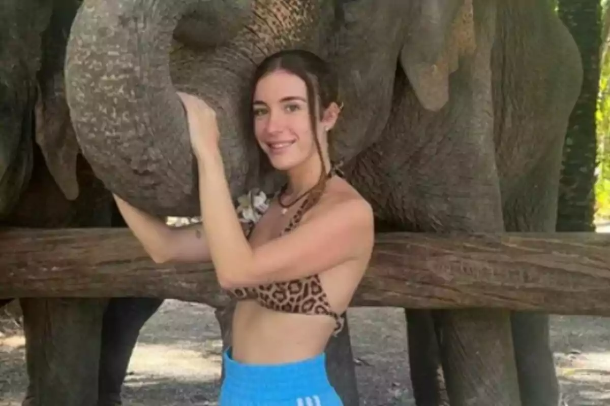 Persona somrient amb un elefant en un entorn natural. Persona somrient amb un elefant en un entorn natural.