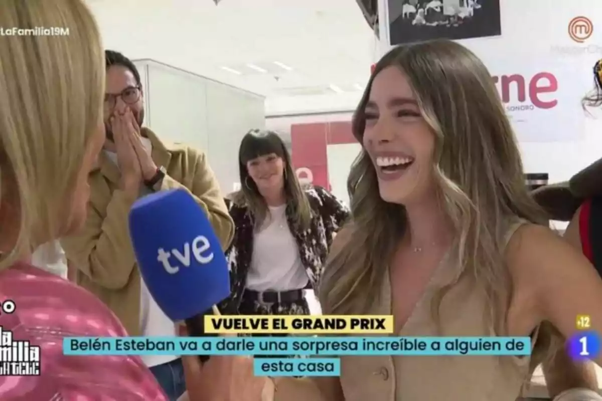 Ángela Fernández somrient sosté un micròfon de TVE mentre conversa amb altres persones que semblen sorpreses i felices en un entorn interior. Ángela Fernández somrient sosté un micròfon de TVE mentre conversa amb altres persones que semblen sorpreses i felices en un entorn interior.