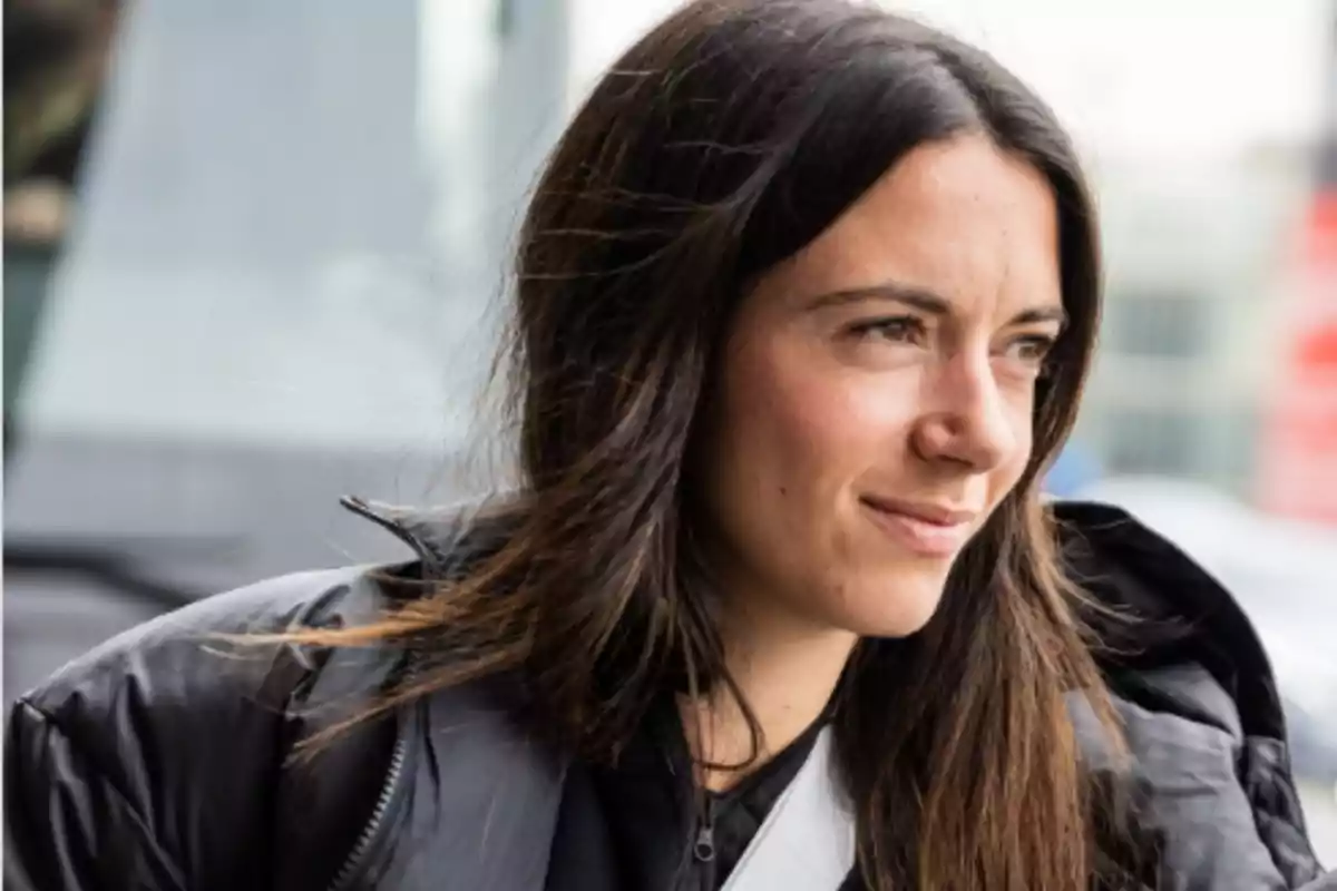 Woman in a black jacket looking to the right in an urban setting. Woman in a black jacket looking to the right in an urban setting.