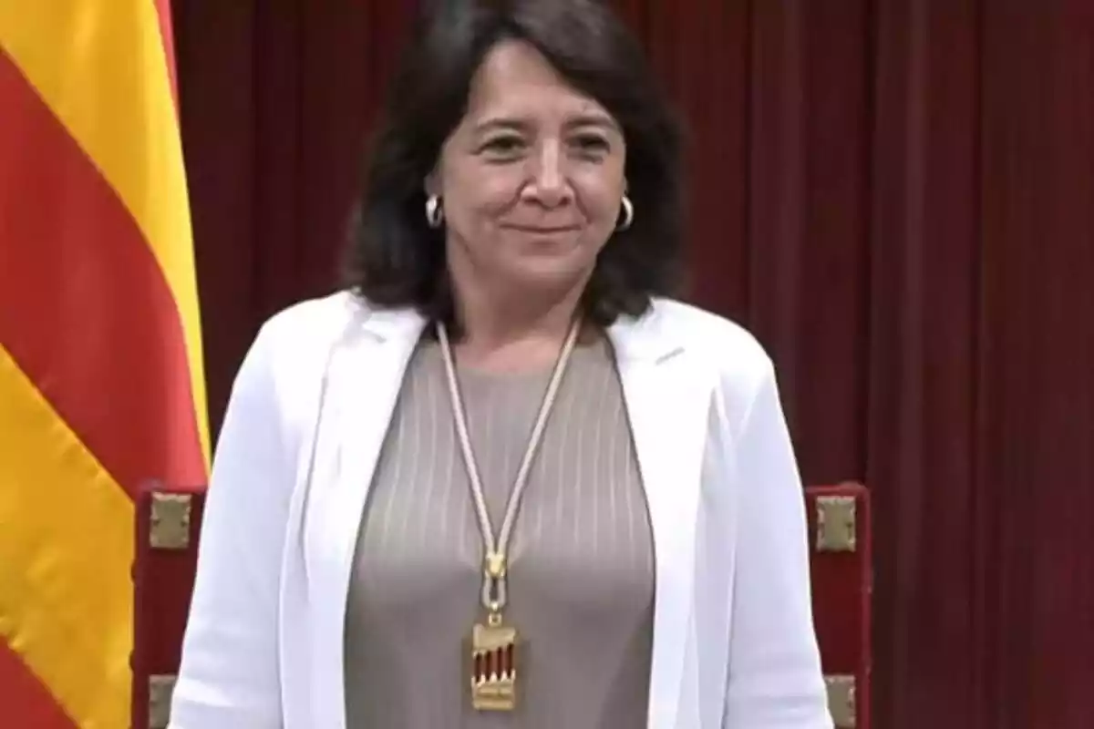 Foto a mig cos d'Anna Erra, de peu, amb la medalla de presidenta del Parlament de Catalunya
