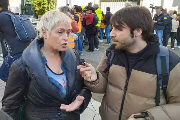 Pla mitjà d'Anna Grau atenent el micròfon d'E-Notícies que subjecta Arnau Borràs