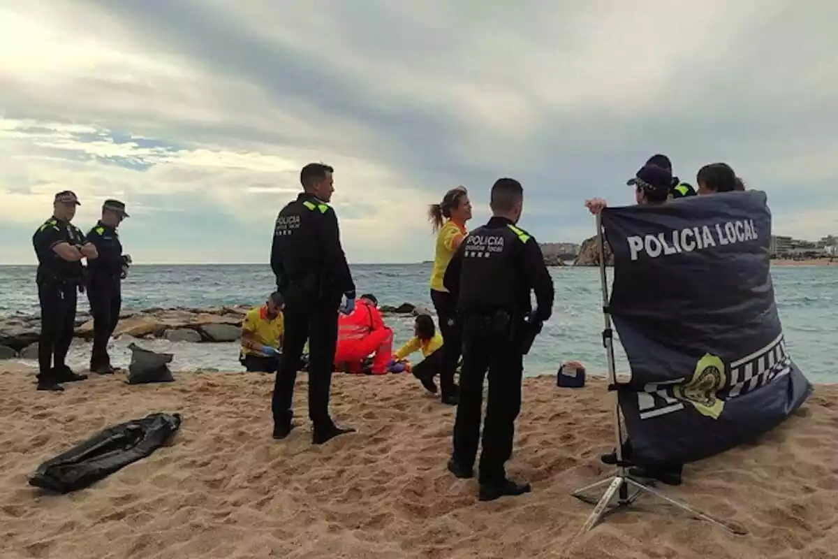 Imatge de la Policia Local de Blanes i de personal sanitari a la platja on ha aparegut el cadàver de la dona