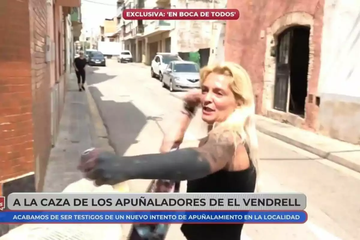 Captura d'una dona rossa amb tatuatges sent entrevistada per En boca de todos davant una porta blava.