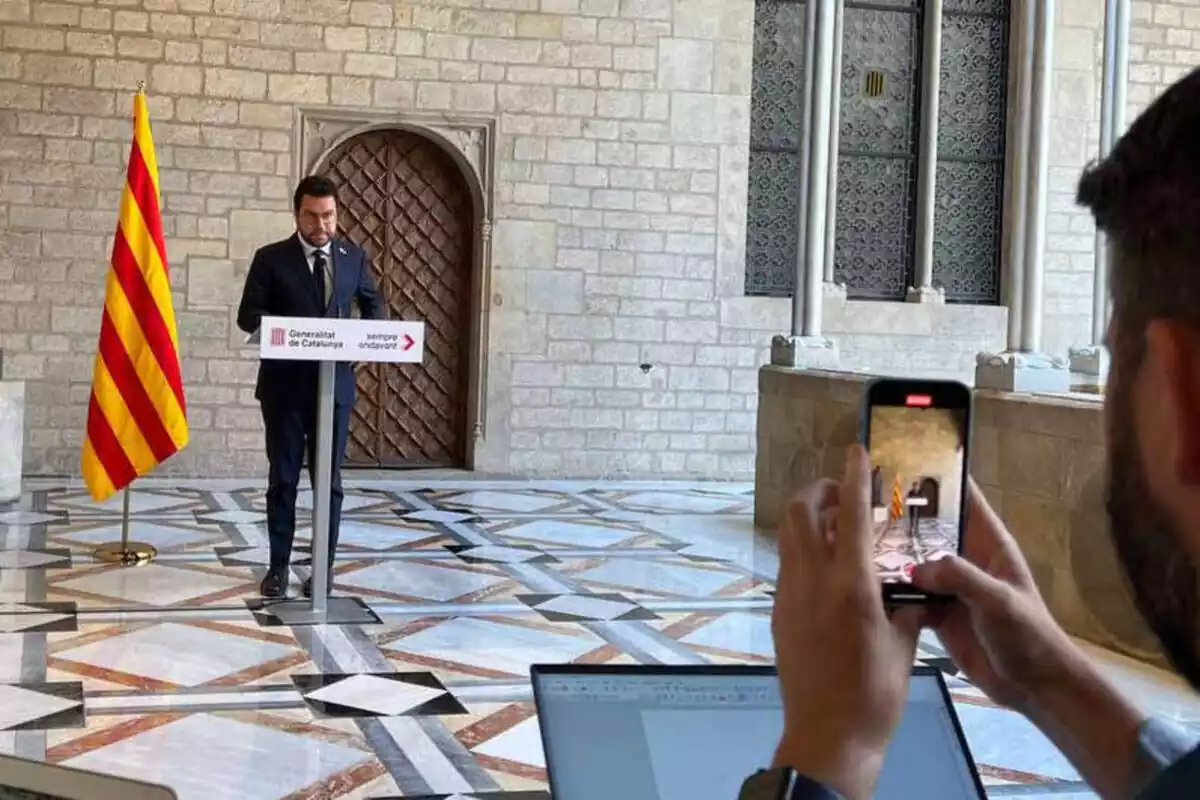 Imatge del president Pere Aragonès al Palau de la Generalitat amb un periodista fent una foto