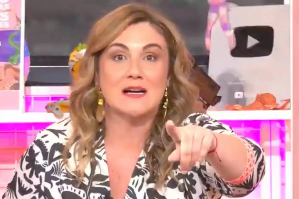 Carlota Corredera amb cabell ondulat i ros assenyala cap endavant en un entorn acolorit amb un botó de reproducció de YouTube al fons a 'Tentáculos'.