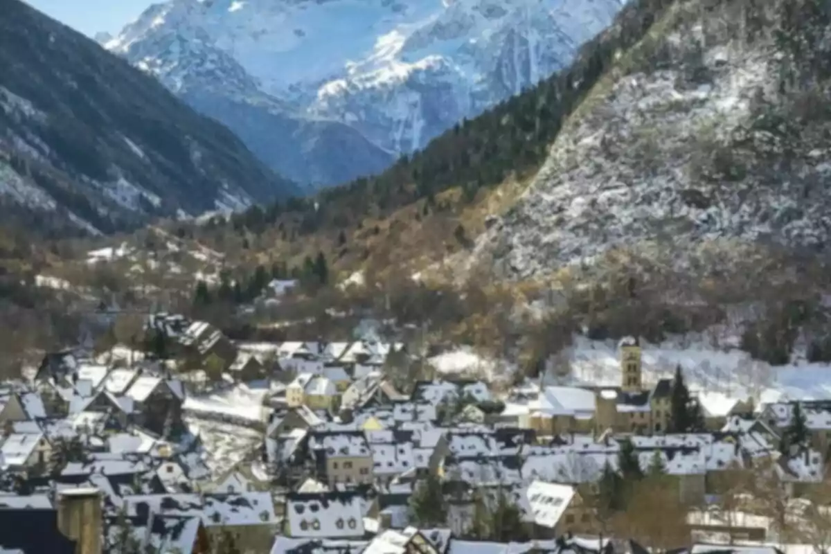 Un pueblo cubierto de nieve rodeado de montañas nevadas.