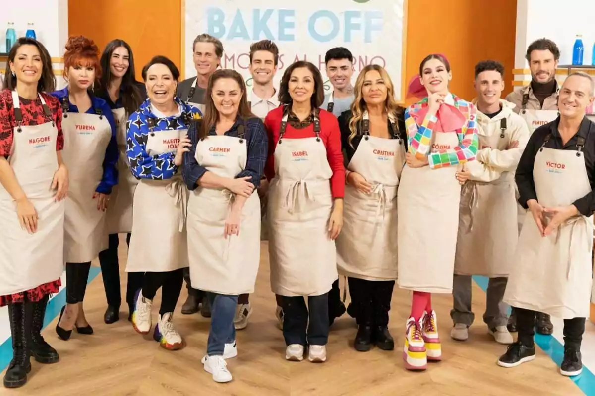 Los concursantes de Bake off: Famosos al horno sonríen mientras posan juntas, todas llevan delantales con nombres y están en un ambiente de cocina con un cartel de "Bake Off" al fondo.