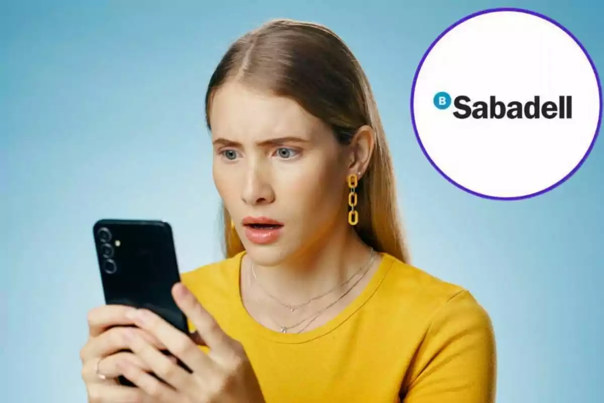 Dona sorpresa mirant el telèfon mòbil amb el logotip de Sabadell al fons.