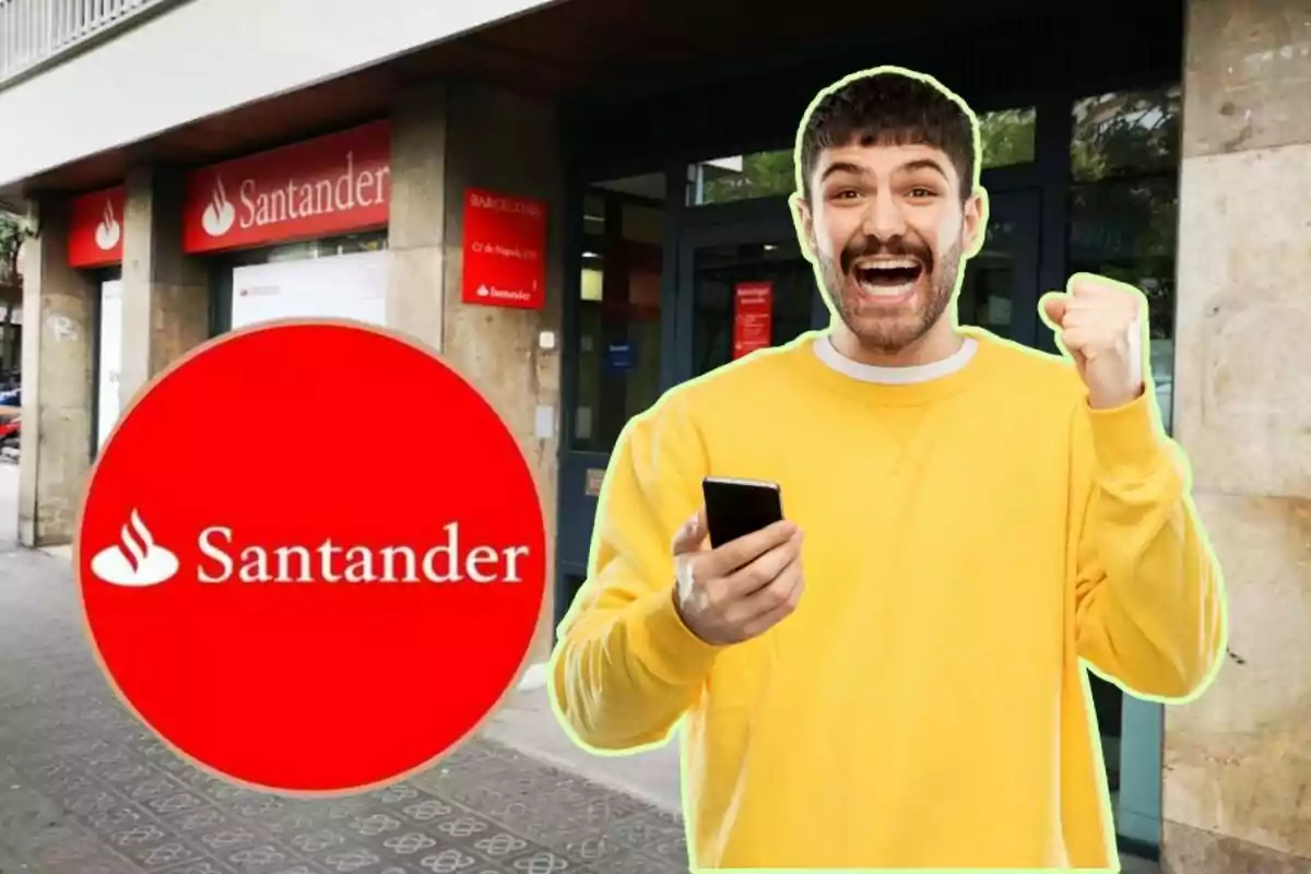 Un hombre sonriente con un teléfono móvil en la mano frente a una sucursal del banco Santander.