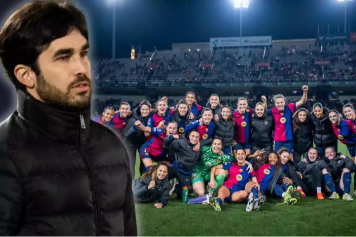 Un home amb jaqueta negra està en primer pla mentre un equip de futbol femení celebra al camp de joc al fons.