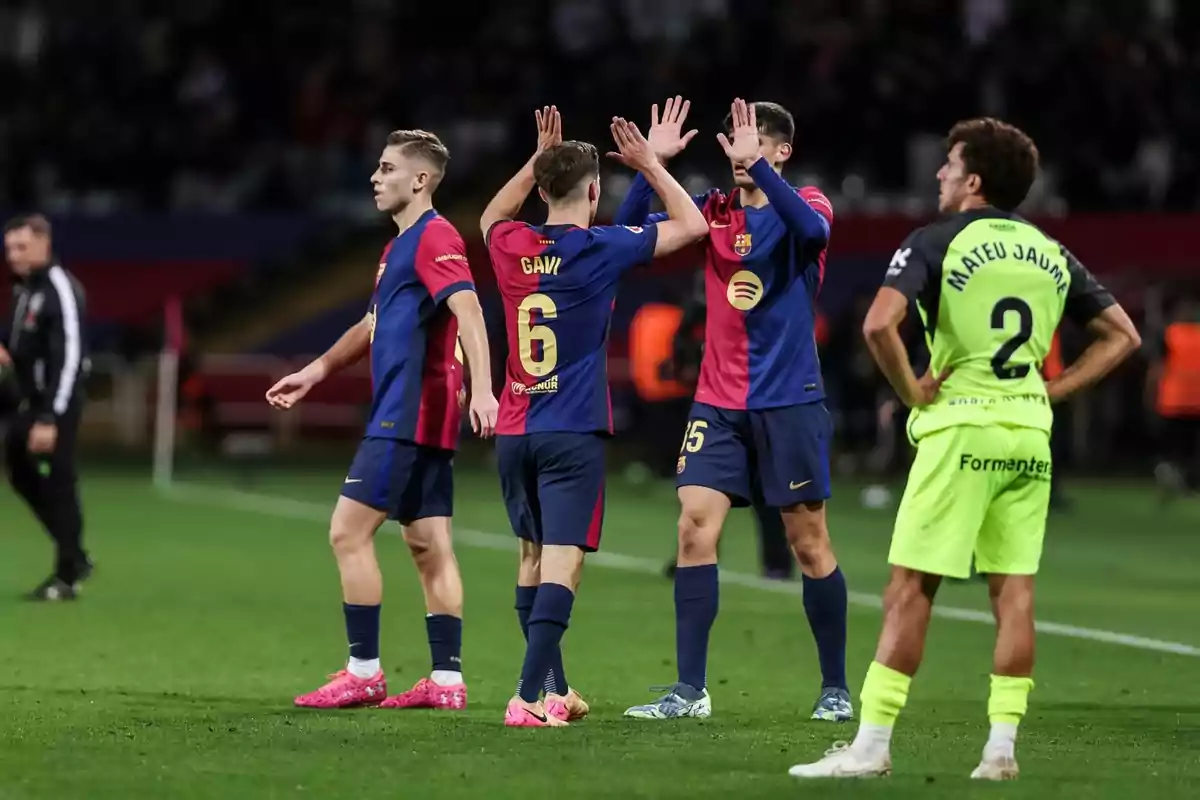 Jugadores de fútbol en el campo celebrando con un gesto de manos mientras otro jugador observa. Jugadores de fútbol en el campo celebrando con un gesto de manos mientras otro jugador observa.